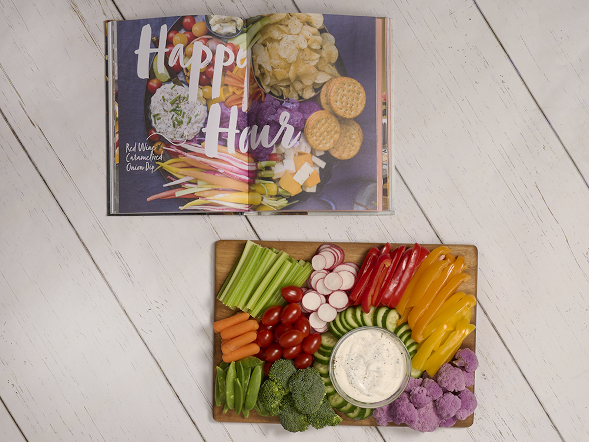 Book open to 'Happy Hour' with charcuterie board