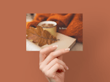 Hand holding card with fall leaf, cup with hot beverage, orange blanket, and words 'hi there'